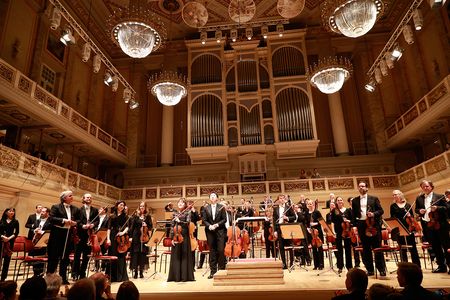 Stehendes Orchester auf der Bühne des Berliner Konzerthauses während des Schlussapplauses
