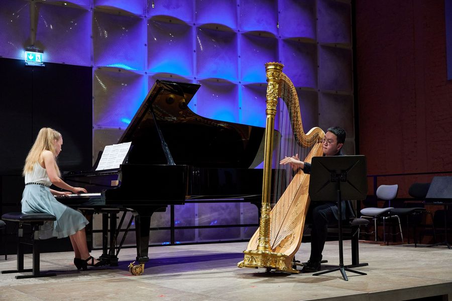 Harfenist und Pianistin musizieren auf der Bühne