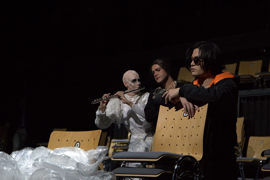 Drei Sänger in Kostüm sitzen auf Stühlen