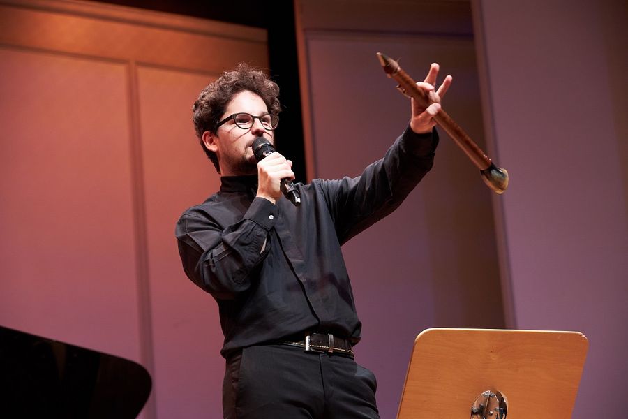 Mann steht auf der Bühne des Kleinen Saals im Berliner Konzerthaus und spricht in ein Mikrofon  