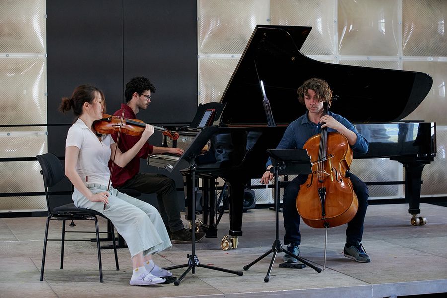 Cellist, Geigerin und Pianist auf der Bühne des Krönungskutschensaals