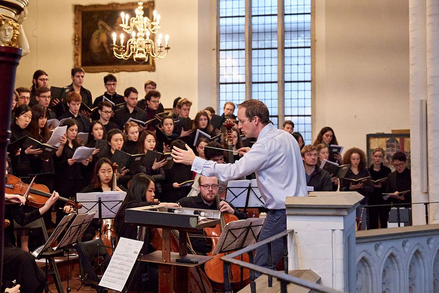 Professor Justin Doyle dirigiert einen Chor aus Studierenden