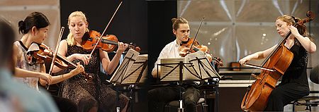 Vier Musizierende mit Streichinstrumenten und Notenständern bei einem Konzert