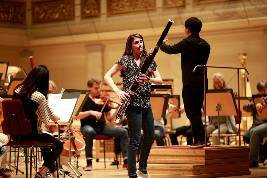 Fagottsolistin und Dirigent vor einem Orchester auf der Bühne des Berliner Konzerthauses