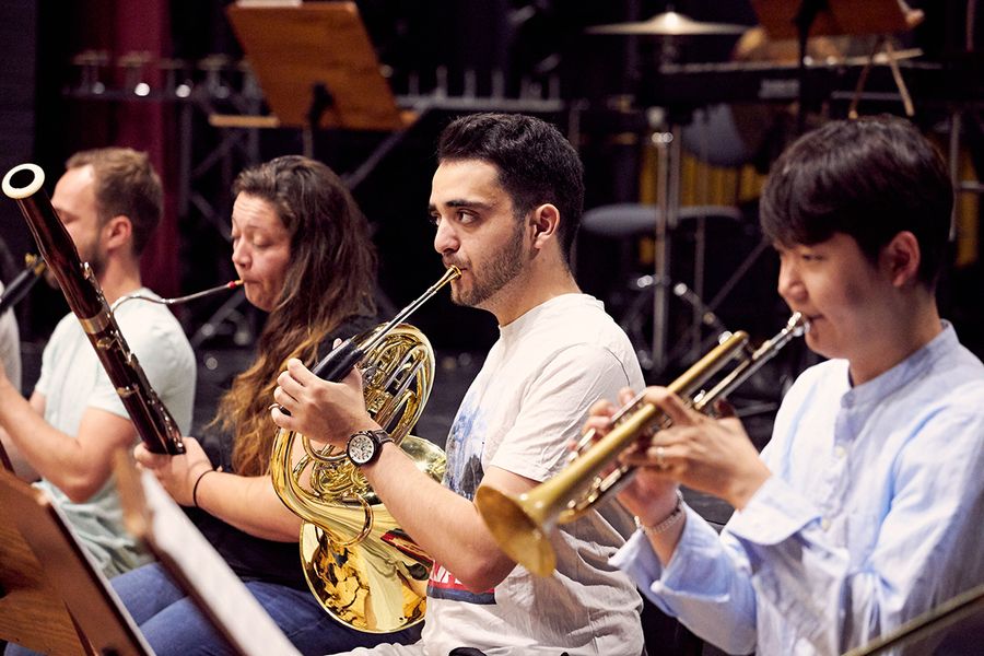 Studierende spielen Fagott, Horn und Trompete während einer Probe