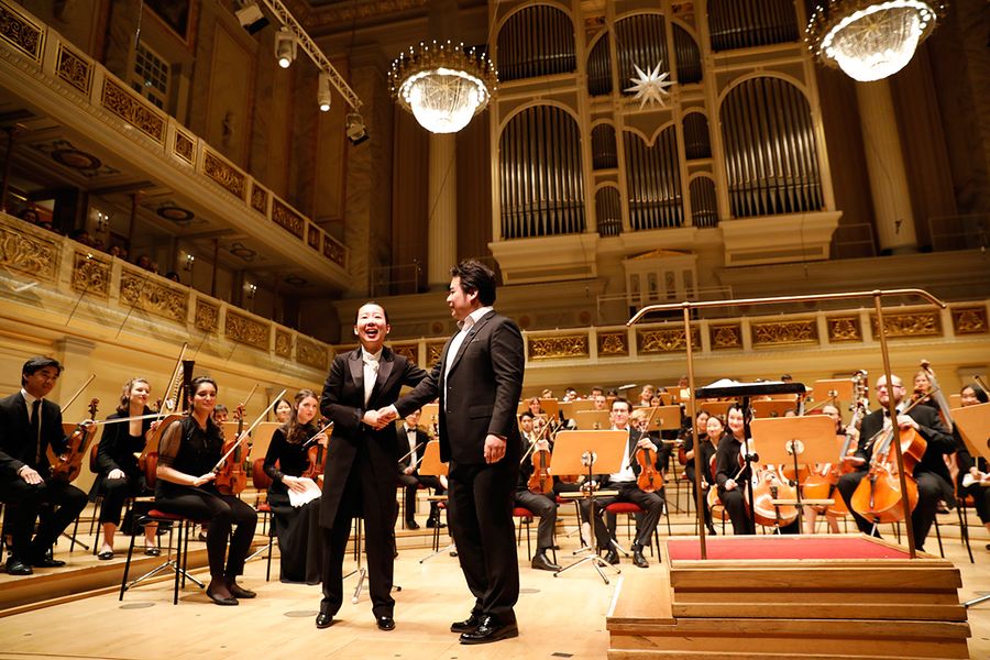 Sänger und Dirigentin vor dem Orchester auf der Bühne des Berliner Konzerthauses