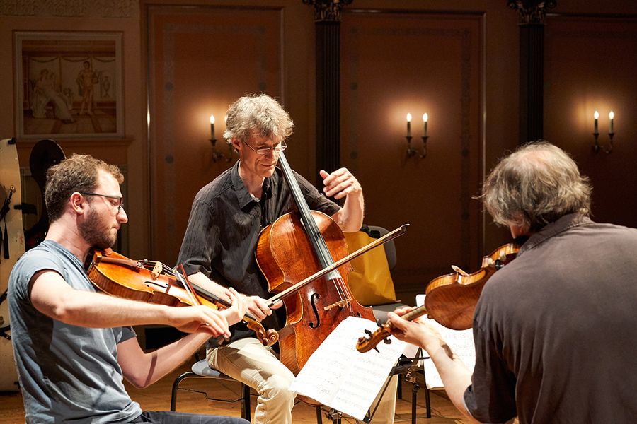 Zwei Professoren und Student mit Geige, Bratsche und Cello während einer Probe