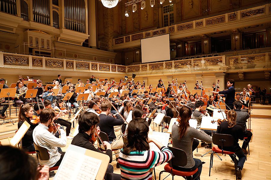 Orchester mit Dirigent auf einer Bühne