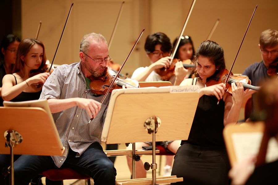 Professor Kolja Blacher und Studierende mit Geigen und Bratschen während einer Probe