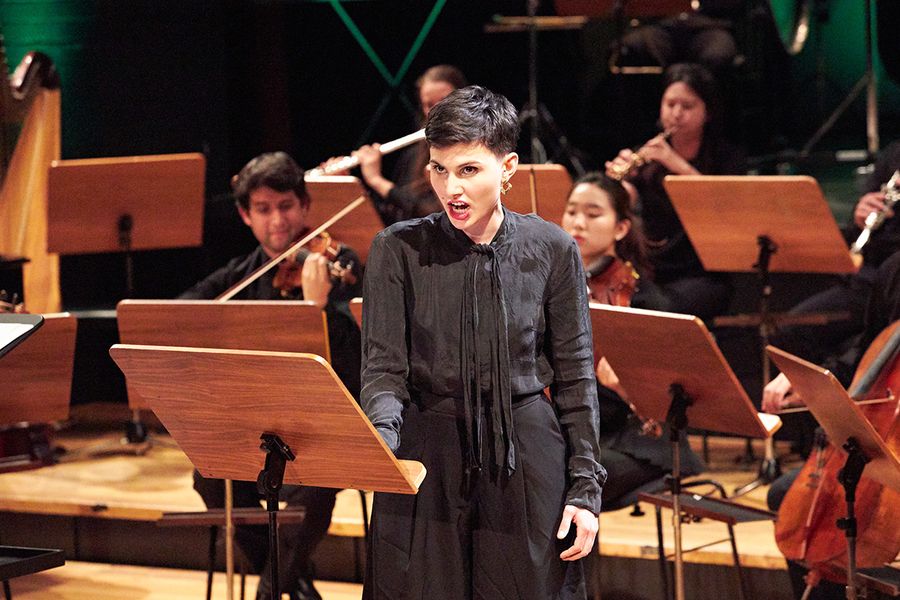Singende Studentin vor einem Ensemble während eines Konzertes