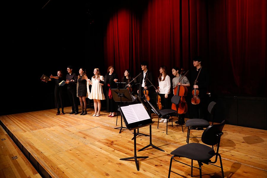 Gesangstudierende stehen in einer Reihe zum Applaus auf der Bühne des Studiosaals