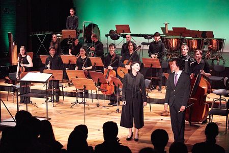 Sängerin und Professor Manuel Nawri mit Ensemble auf einer Bühne während des Schlussapplauses