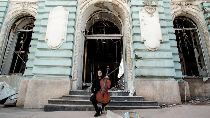 Cellist vor einer alten Gebäudefassade