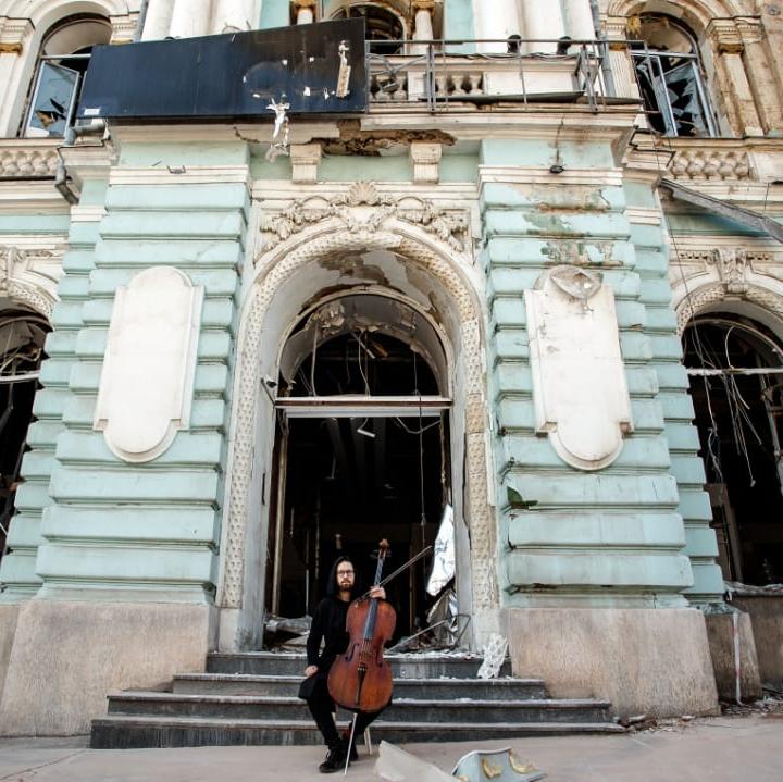 Cellist vor einer alten Gebäudefassade