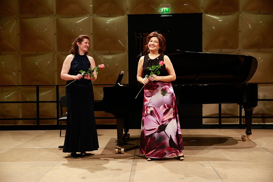 Professorin Anna Korondi und Pianistin mit Rosen während des Applauses auf einer Bühne