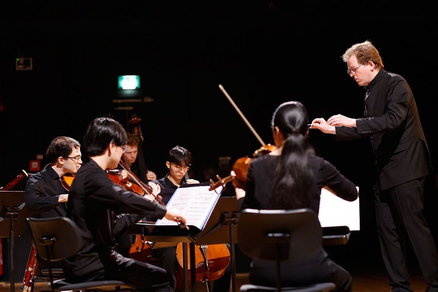 Dirigent vor einem Orchester aus Studierenden