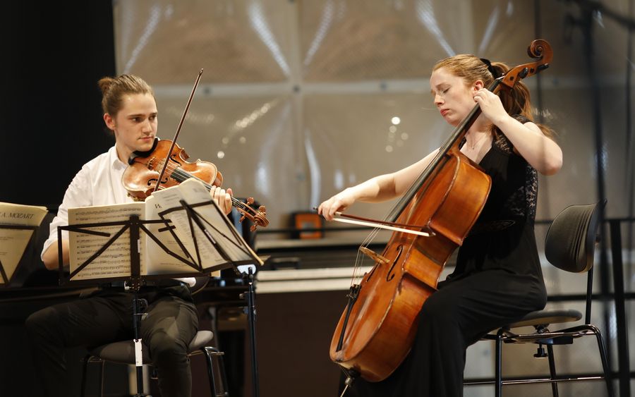 Ein Mann mit Bratsche und eine Frau mit Cello auf einer Bühne 