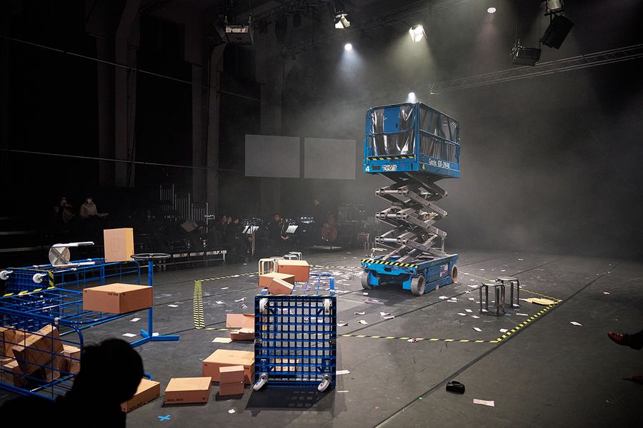 verstreut auf der Bühne liegende Kartons und blaue Rollwagen