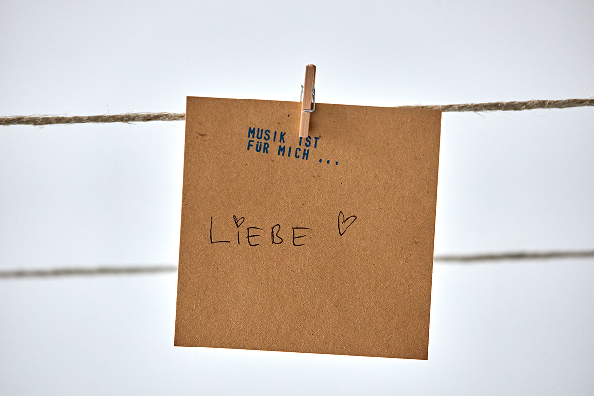 A piece of paper with the inscription "Music is for me... Love", hung on a taut string